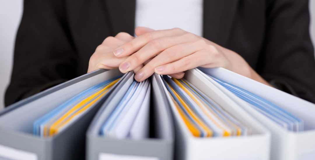 Midsection of businesswoman with binders at office